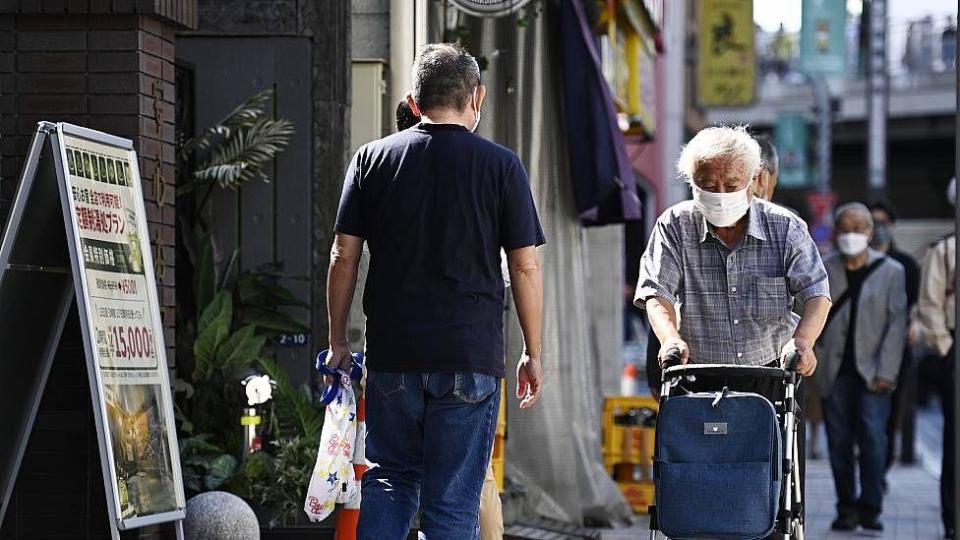 An old man walks with a walker in Japan