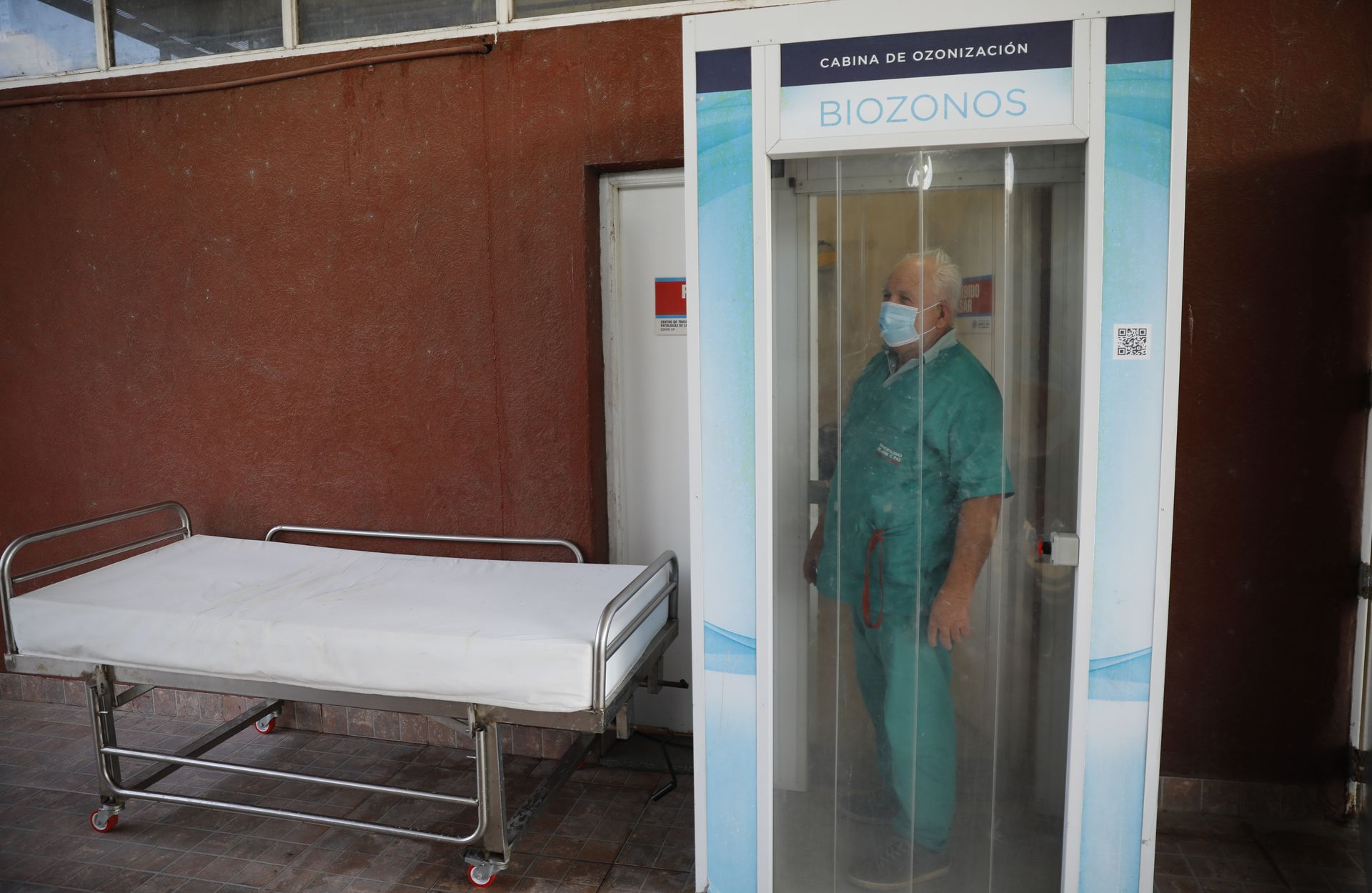 A health worker disinfects himself in the ozone room upon leaving the intensive care unit at the Domingo Angio Municipal Hospital in Jose C Paz 