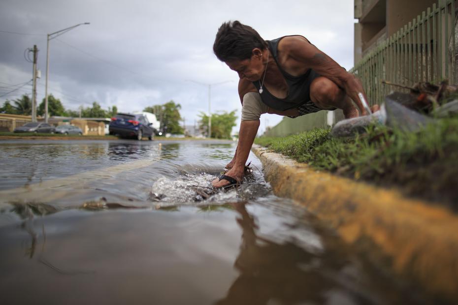 He belongs to the Juana Matos community in Catano and is trying to open a blockage in the sewer.