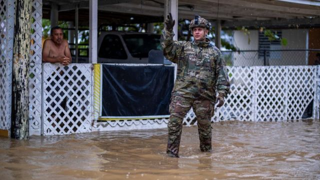A soldier stands in a flooded area in Puerto Rico.