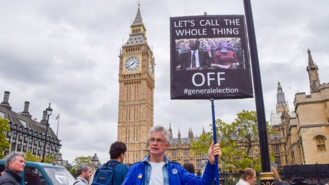 A man holds a sign calling for a general election in the United Kingdom